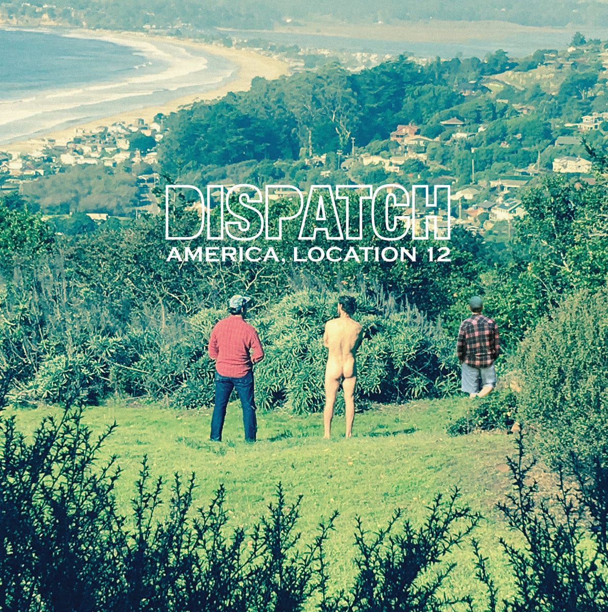 Three men (one of whom is naked) standing facing away from the camera on a hill overlooking a beach. 